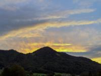 Wolkenstreifen und Wolkenfetzen vom letzten Sonnenlicht angestrahlt